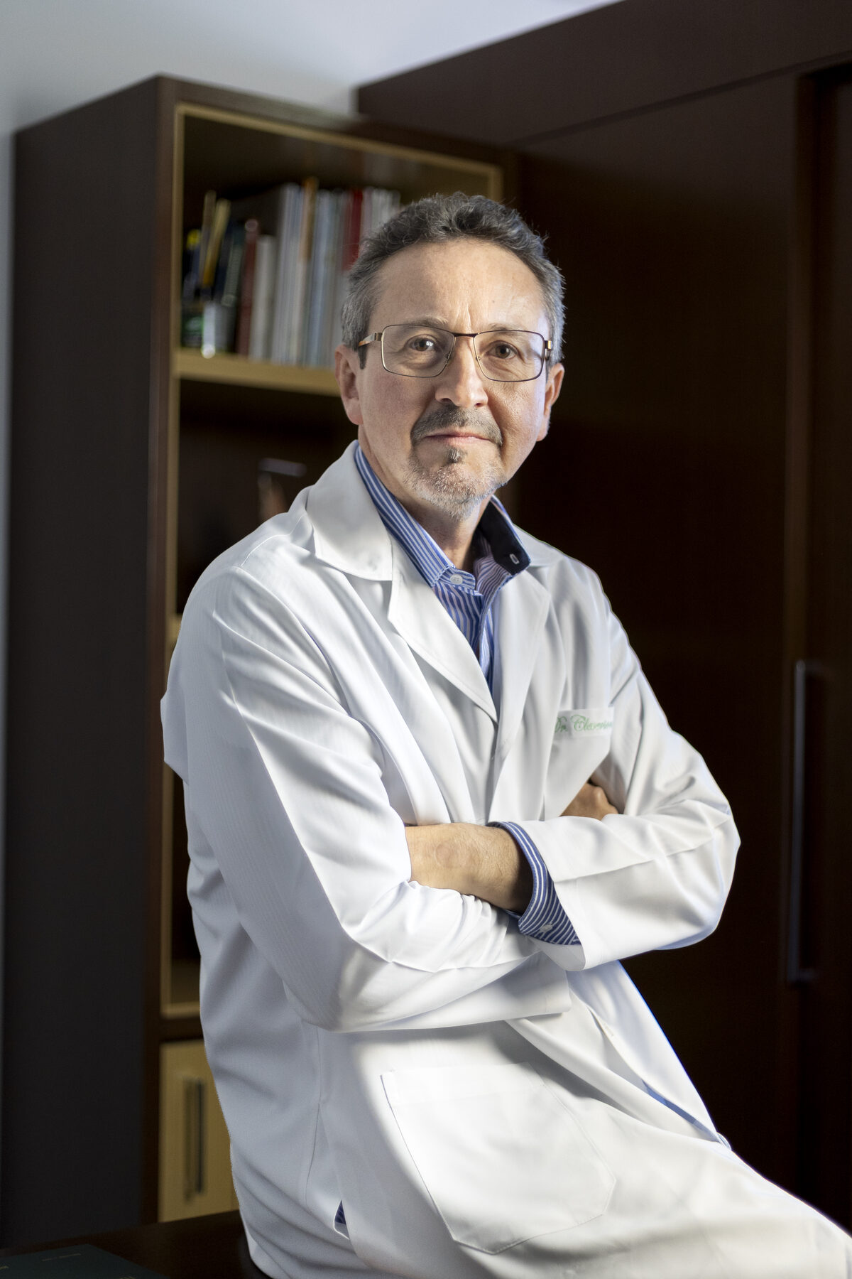 Dr. Cleverson Urcichi em seu consultório, com jaleco branco